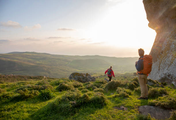 istock Hiking couple relax in meadow, below rock bluff 1204060530