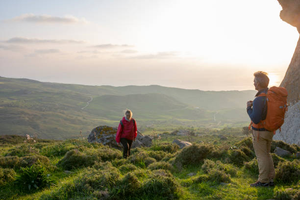 istock Hiking couple relax in meadow, below rock bluff 1204060538