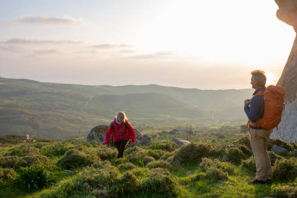 istock Hiking couple relax in meadow, below rock bluff 1204061643