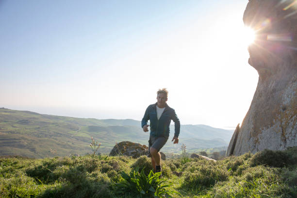 istock Male trail runner ascends trail through meadow 1204061726