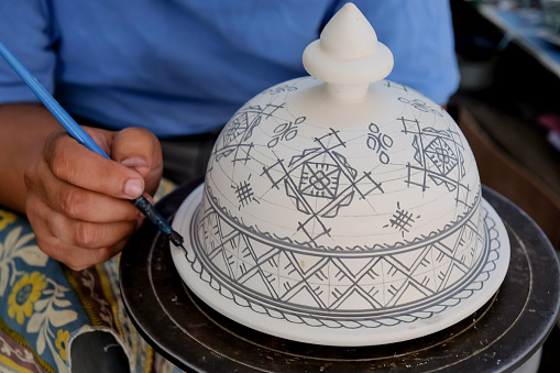 Close up shot male artist drawing Islam mozaic pattern on ceramic