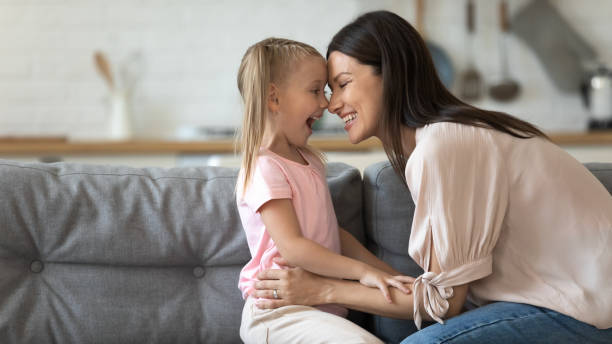 istock Smiling mom and daughter cuddle playing at home 1204066333