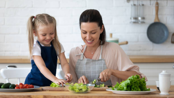 istock Happy little girl help mom cooking in kitchen 1204066361