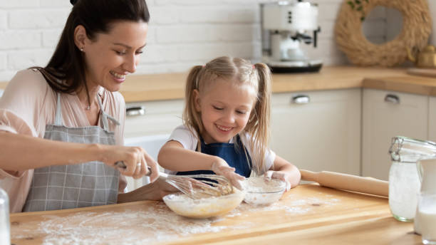istock Happy mom and daughter prepare pie in kitchen 1204066369