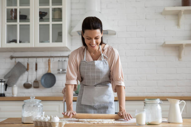 istock Smiling young woman making dough baking pastries 1204066372