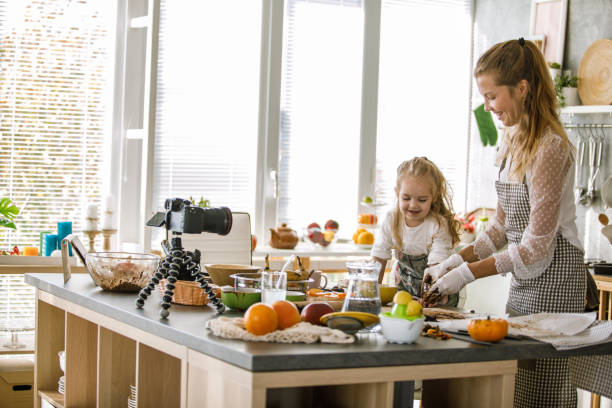 istock Vlogger having fun while filming a cookie video with her toddler daughter 1204066535