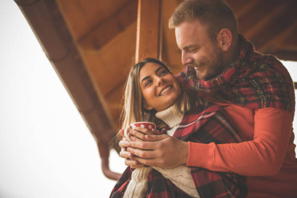 istock Affectionate young couple cuddling and warming their hands on a cup of tea 1204067898