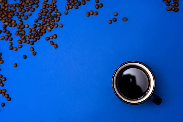 istock Top view of Cup of coffee on blue background 1204068165