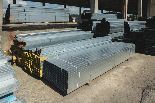 Square metal pipes stacked for sale.