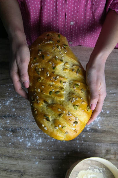 Closeup of fresh rustsic bread in a woman's hand