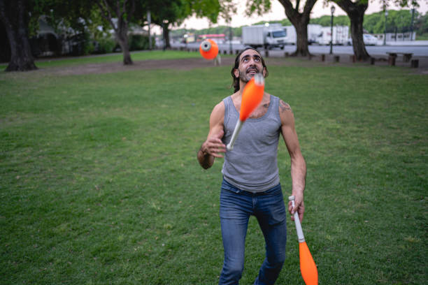 istock Skilled and focused Hispanic juggler juggling at a park 1204070975