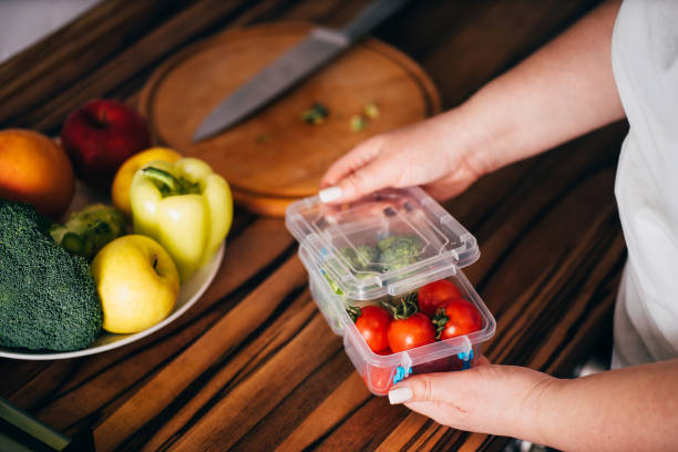 istock Woman serving lunch in plastic box.Take away food. 1204077194