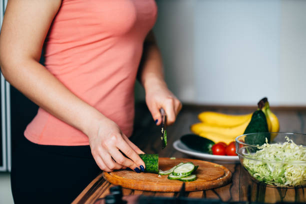 istock Fit woman cooking vegetable salad at her kitchen 1204077252