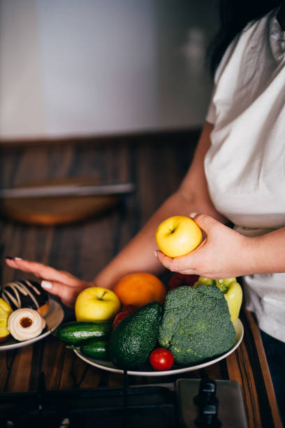 istock Obese woman choosing healthy refusing junk food 1204077305