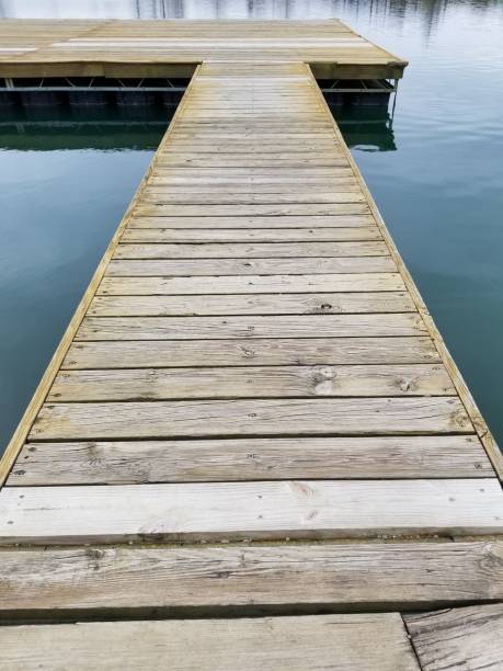 istock Wooden dock walkway over water perspective background 1204077447