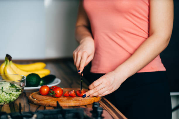 istock Fit woman cooking vegetable salad at her kitchen 1204077451