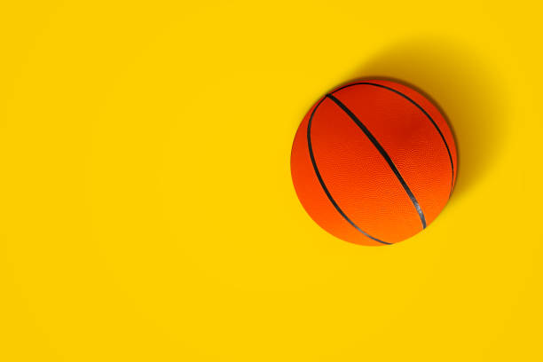 Basketball in vibrant color Basketball in vibrant color on yellow background floor length stock pictures, royalty-free photos & images