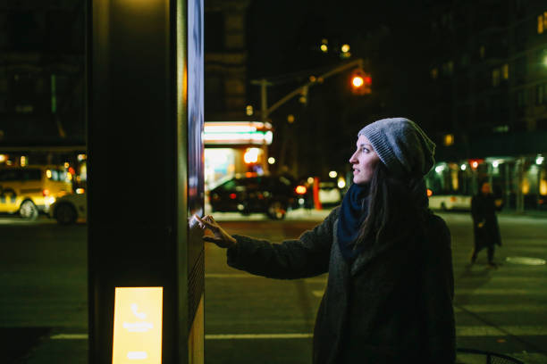 woman using touch screen city display - billboard symbol city street imagens e fotografias de stock