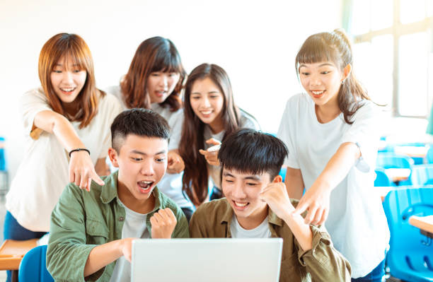 istock happy students looking at laptop  in classroom 1204083231