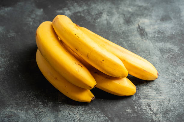 istock Branch of bananas on the rustic background 1204084447