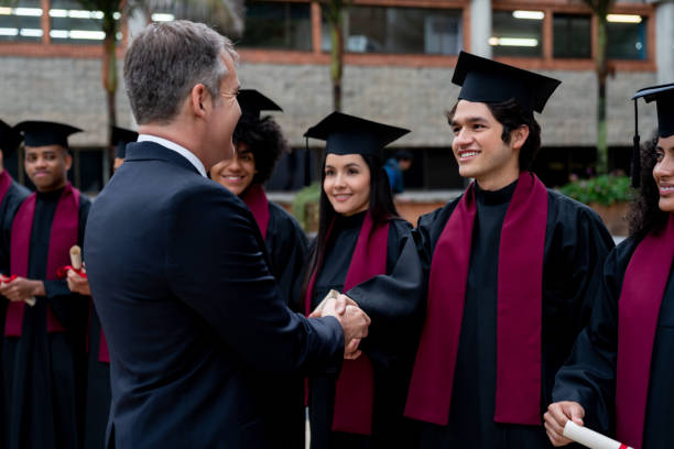istock Dean handshaking with students on their graduation day 1204089357
