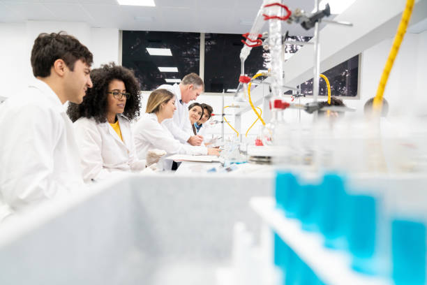 istock Teacher talking to a group of students in chemistry class 1204089398