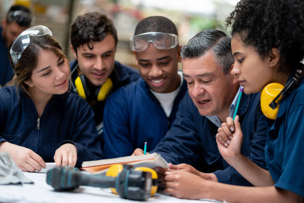 profesor hablando con un grupo de estudiantes de diseño industrial - aprendiz fotografías e imágenes de stock