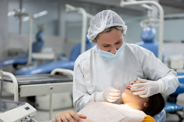 istock Dentist examining a female patient 1204090160