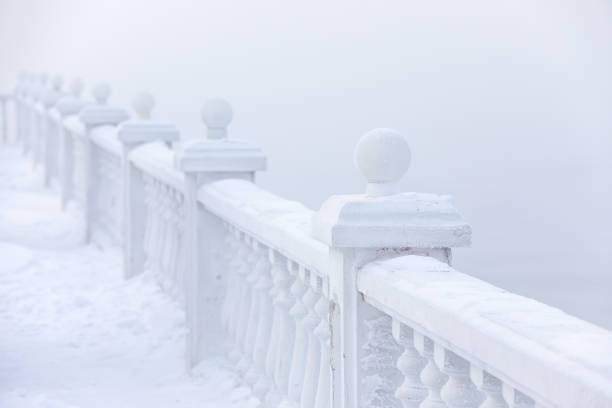 Frost and ice covered balusters on a lake shore in winter. Lake Baikal, Listvyanka, Siberia, Russia.