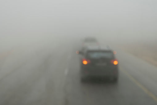 Poor visibility on the road. Fog early in the morning on the highway. slow-moving cars in heavy smoke from forest fires. Dangerous traffic. Bad weather. Slippery asphalt. driver's eyesight is poor.