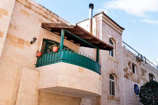 Beautiful summer balcony on an unknown two-storey building. The facade of the building with the architecture of the middle East. spikes on the railing of the balcony