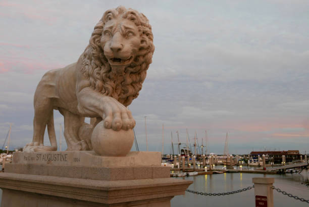 Lion sculpture on the Bridge of Lions in St. Augustine, Florida Close up of a lion sculpture at the end of the historic Bridge of Lions in Old Town St. Augustine, Florida, USA, at sunset bridge of lions stock pictures, royalty-free photos & images