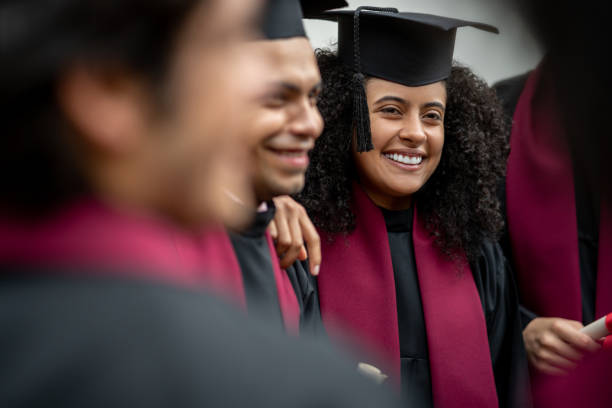 Female student looking happy on her graduation day Happy female student with a group of friends on her graduation day  - education concepts alumni stock pictures, royalty-free photos & images