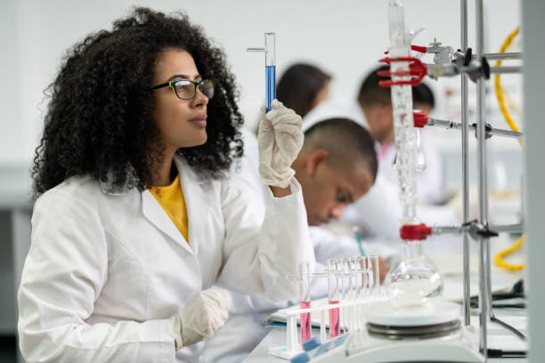 STEM female student in class at the lab Portrait of a STEM female student in class at the lab looking at a test tube â education concepts african american scientist stock pictures, royalty-free photos & images