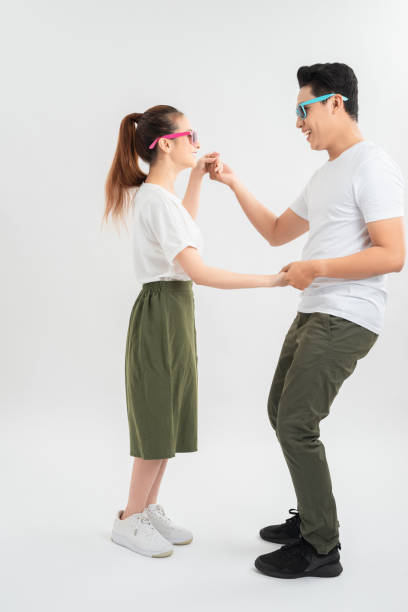 istock Smiling couple dancing and holding hands, isolated on white 1204096316