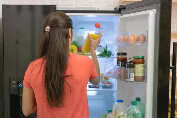 istock Happy woman at home putting things in the fridge 1204096366