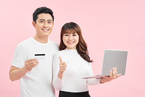 happy man holding credit card while girlfriend showing thumb up sign