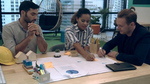 istock Creative business people group having conversation at office desk in workplace. 1204102936
