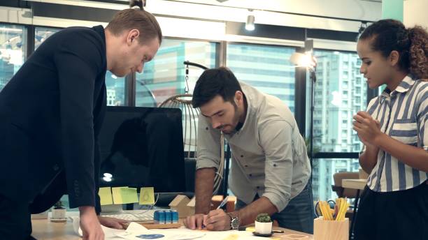 istock Creative business people group having conversation at office desk in workplace. 1204102945