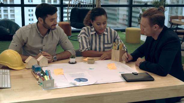 istock Creative business people group having conversation at office desk in workplace. 1204102969