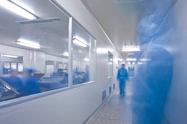 Chinese hospital laboratory working Chinese hospital laboratory working with unrecognizable technician in blue cleanroom photos stock pictures, royalty-free photos & images