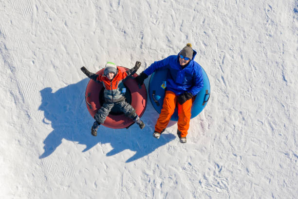 padre e hijo tubos de nieve en el invierno en canadá - deslizarse en trineo fotografías e imágenes de stock
