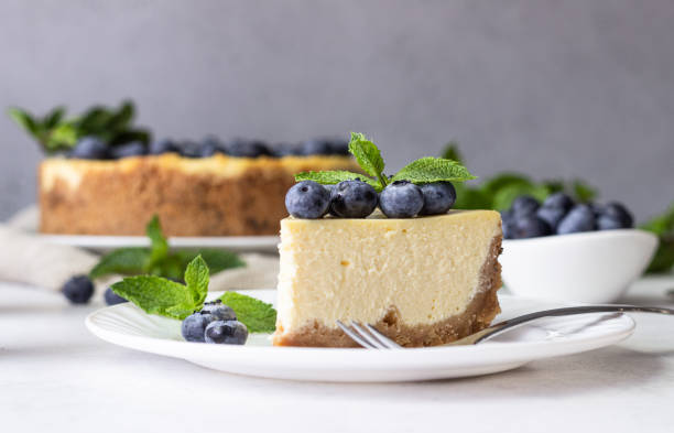 istock New York style cheesecake, blueberries and mint on a white plate. 1204107308