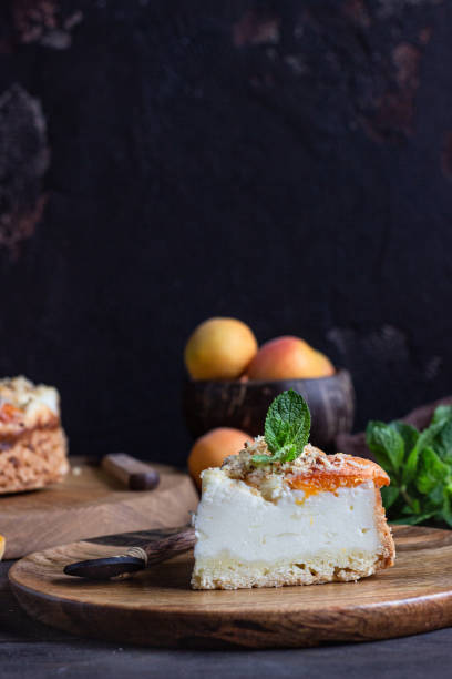 Cheesecake with apricot and crumble, fresh apricots and mint. Rustic style.