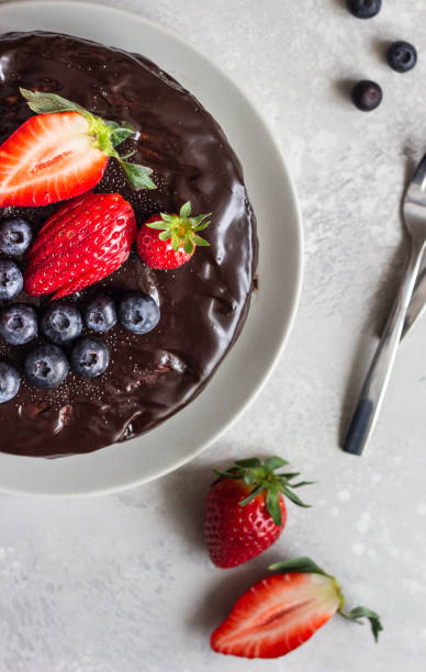istock Cheesecake with raisin decorated with chocolate glaze, strawberries and blueberries. 1204108580