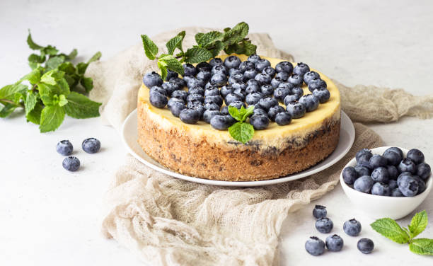 istock New York style cheesecake, blueberries and mint on a white plate. 1204108667