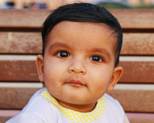 istock one year old cute baby boy looking something with a  little smile 1204108802
