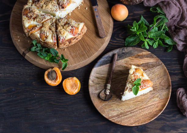 istock Cheesecake with apricot and crumble, fresh apricots and mint. Rustic style. 1204108803