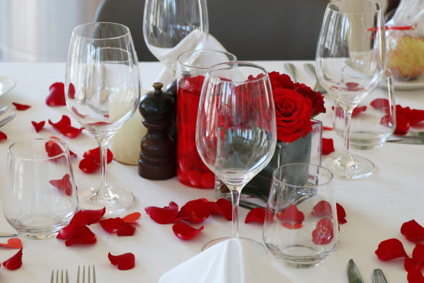 istock valentine's day special dining table set up with wine glasses and red rose petals 1204108837