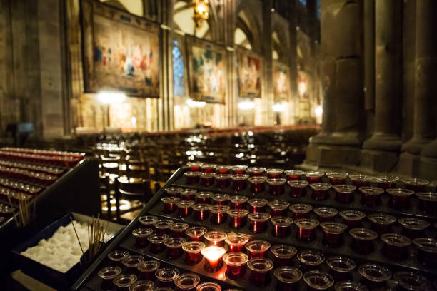 istock Lighting candles in a catholic temple . 1204109960
